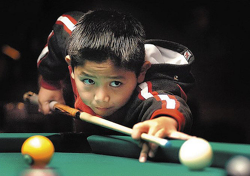 Niño jugando al billar Niño jugando al billar